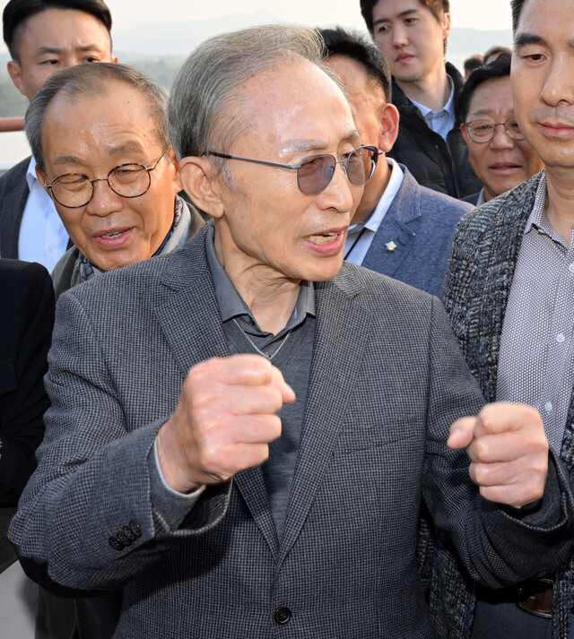 이명박 전 대통령이 25일 경기 여주시 한강문화관에서 열린 4대강 보 걷기 행사에서 ‘이포보, 여주보, 강천보를 지키는 모임’ 관계자를 비롯한 지지자들과 강천보를 걸으며 취재진 질문에 답하고 있다. /연합뉴스