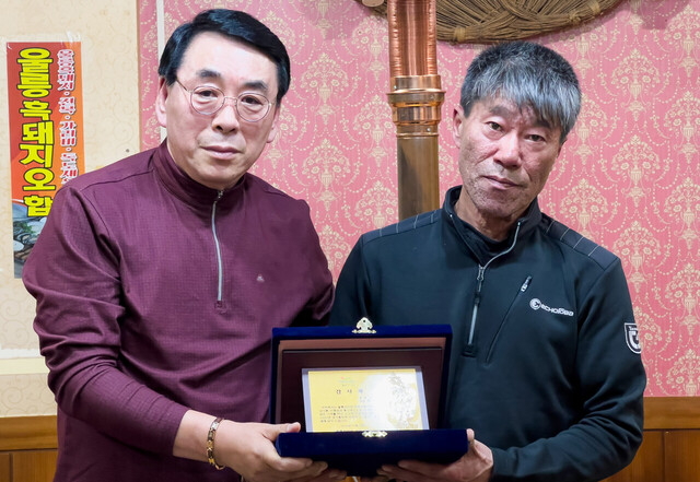 김두한 울릉군산악연맹회장이 이임하는 최희찬 울릉산악회장에게 감사패를 전달하고 있다.