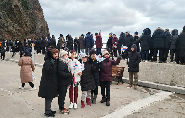 울릉도 저동암 촛대암에서 해맞이를 한 관광객들이 기념사진을 찍고 있다. 