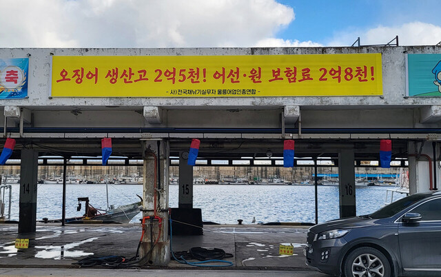 어민 단체가 내건  오징어 생산보다 어선 선원 보험료가 더 많다는 현수막.