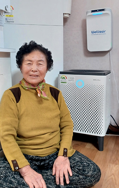 공기청정기 옆에 앉은 포동댁 모습이 정겹다. 거친 손마디가 만만찮은 삶을 대변한다.