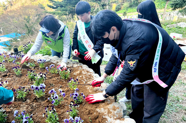 여성단체 협의회 자원봉사자와 청소년, 경찰관이 함께 화단을 조성하고 있다. /울릉경찰서제공