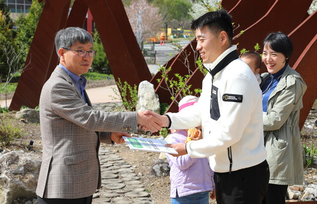 17일 국립백두대간수목원에서 류광수 한국수목원정원관리원 이사장(왼쪽)이 400만번째 관람객 김민석씨에게 선물을 전달하며 악수를 하고 있다.  /백두대간수목원제공