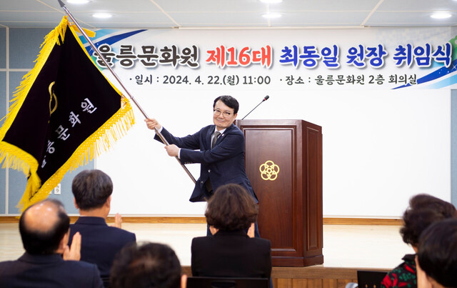 문화원 기를 이양받고 힘차게 흔드는 최동일 신임 울릉문화원장. /울릉문화원제공