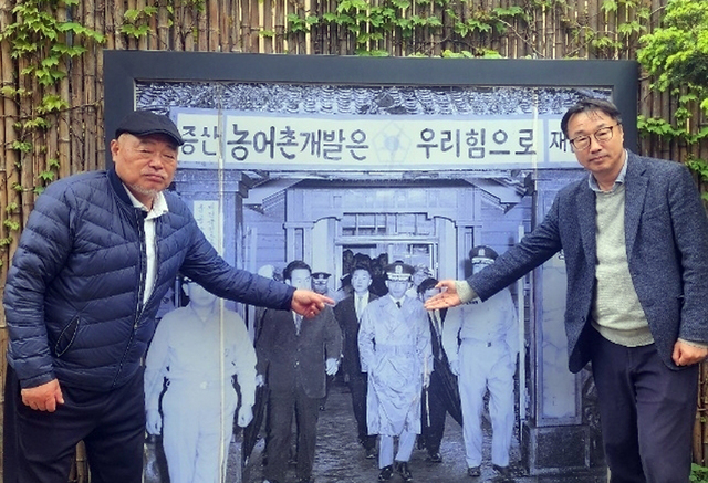 김흥국회장이 김윤배 대장과 함께 울릉군청을 방문한 박 전 대통령 사진을 가르키고 있다./김두한 기자 