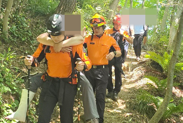 울릉119안전센터 산악구조대원이 다친 등산객을 업고 하산하고 있다./울릉119안전센터