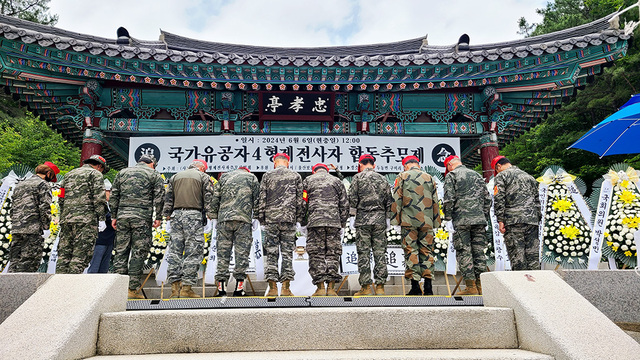 현충일인 지난 6일 울산시 울주군 두동면에서 열린 국가유공자 4형제 전사자 합동추모제에서 해병예비역이 헌화하는 모습.