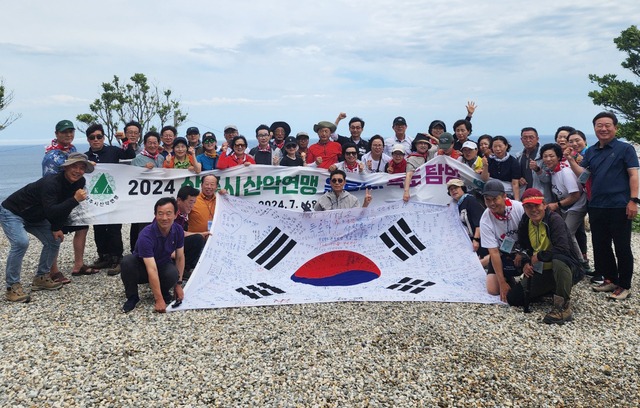 독도수호, 독도사랑을 다짐하는 산악인들의 글이 적힌 태극기를 펼치고 파이팅을 외치고 있다./김두한 기자