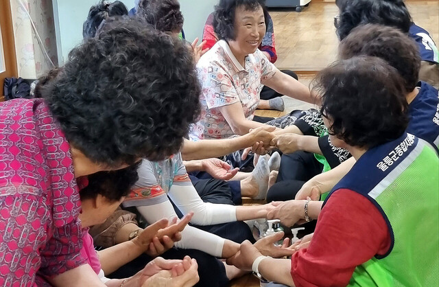 울릉군자원봉사자들이 손마사지를 통해 어르신들의 건강을 챙기고 교감을 하고 있다./울릉군자원봉사센터