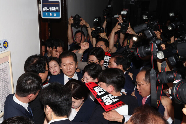 정청래 법제사법위원회 위원장이 국민의힘 의원들의 항의를 받으며 19일  ''윤석열 대통령 탄핵소추안 발의 요청'' 국민동의 청원 청문회가 열리는 회의장으로 향하고 있다./연합뉴스