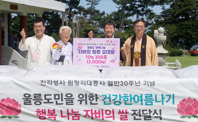 진각종 신도 석복희씨 남한권 울릉군수에게 쌀을 전달하고 있다./울릉군