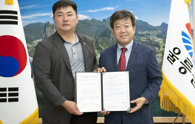 남한권 울릉군수와 전종환 울릉에너지협동조합 대표가 해상운송비지원 및 경북 평균가 판매를 약속하고 서명했다./울릉군