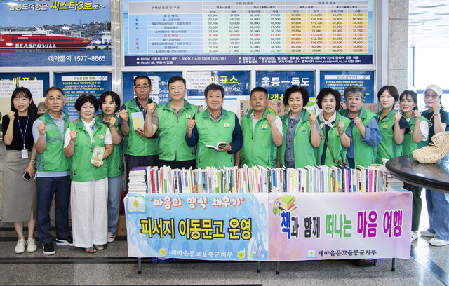 피서지 문고 개소식에 참석한 남한권 울릉군수와 이정호 울릉새마을회장, 심상걸 울릉군새마을지도자협의회장 등 관계자들이 파이팅을 외치고 있다.  /김두한 기자 