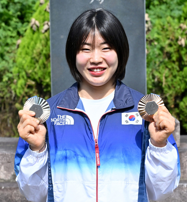 허미미 선수가 현조부인 독립운동가 허석 선생의 기적비 앞에서 자신이 획득한 메달을 들고 기념사진을 찍고 있다. /경북도제공