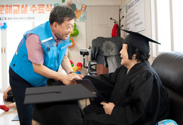 남한권 울릉군수가 성인문해교육을 무사히 마친 어르신을 격려하고 있다./울릉군