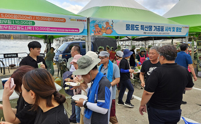 각종 특산음식 부스 앞에서 울릉도 슬로푸드 음식을 즐기고 있다. /김두한 기자 