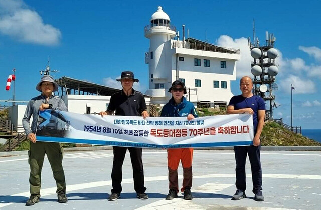 독도 등대를 배경으로 헬기장에서 독도등대 점등 70주년 축하 퍼포먼스. /울릉도독도해양연구기지