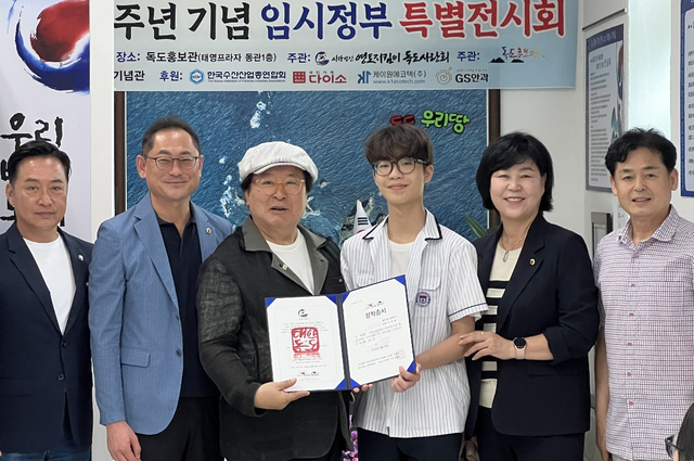 정광택 독도사랑회 장학위원장(좌에서 세번째)이 이태혁 학생에게 장학금을 전달하고 있다. /독도사랑회