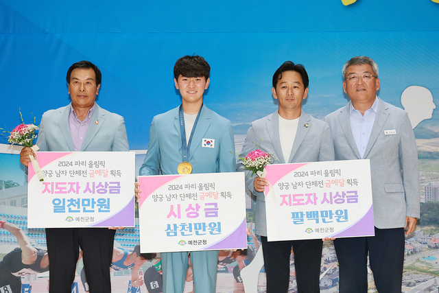 김학동(오른쪽) 예천군수가 김제덕(왼쪽 두번째) 선수와 지도자들에게 시상금을 전달하고 있다. /예천군제공