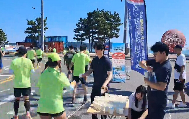 마라톤대회 참가자들이 물을 받아 마시며 뛰고 있다. /대저페리