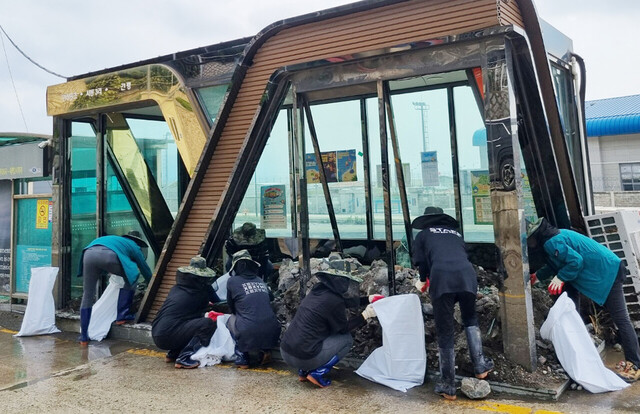 버스정류장에 유입된 토사와 쓰레기를 치우고 있다./울릉군