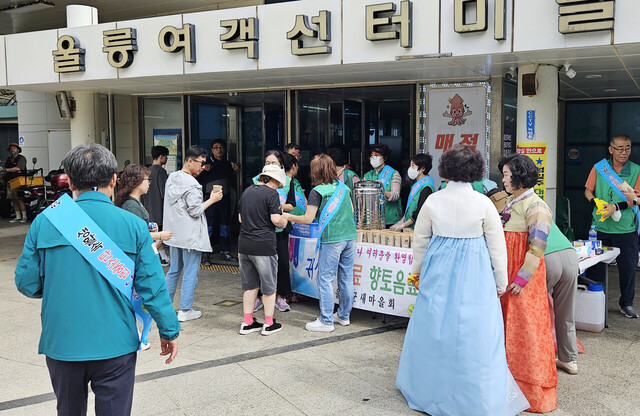 많은 관광객과 귀성객들이 매실차와 호박엿을 받아들고 있다./김두한 기자 