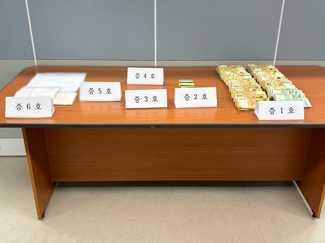 베트남 거점 100억 원대 스미싱 범죄조직이 편취한 현금과 증거품./경북경찰청 제공