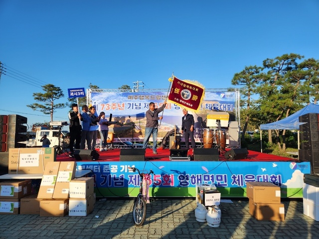 제55회 영해면민체육대회에서 종합우승을 차지한 괴시3리 유순연 이장이 우승기를 흔들고 있다. 