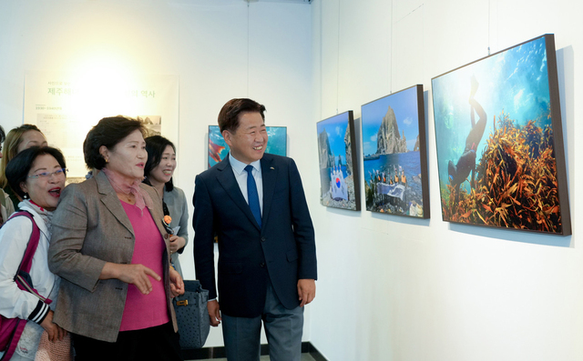 제주해녀와 함께 전시회를 관람하는 오영훈 도지사.