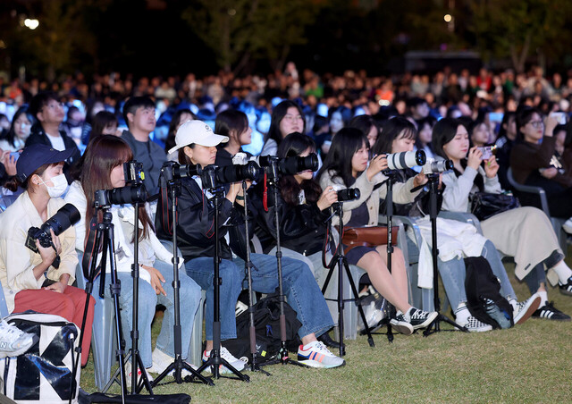 옥상달빛의 팬들이 카메라에 공연 모습을 담고 있다. 
