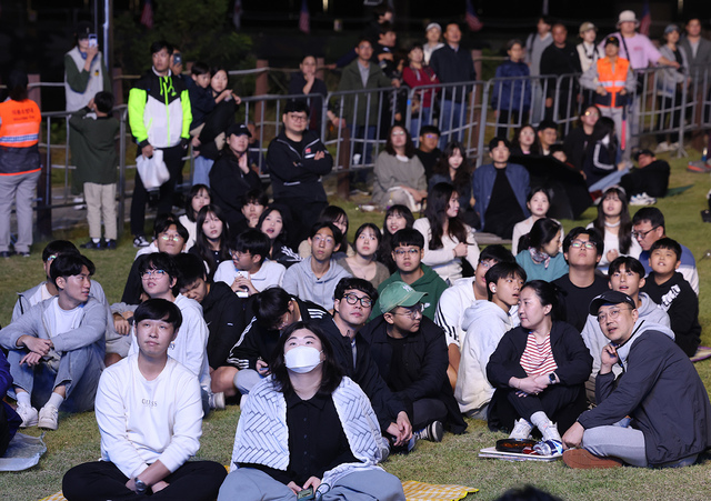 잔디밭에 자리 잡은 칠곡 군민들이 편한 자세로 공연을 즐기고 있다.