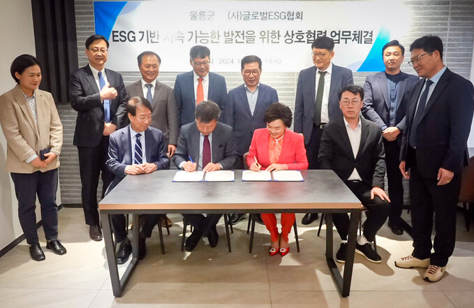 양측관계자들이 참석한 가운데 남한권 울릉군수와 황인경 회장이 업무협약서에 서명하고 있다. 정운찬 전 국무총리(앞줄 왼쪽 첫번째)가 서명 장면을 지켜보고 있다. /울릉군