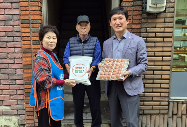최강절 회장(사진 왼쪽)이 쌀과 계란을 전달하고 있다. /울릉농협