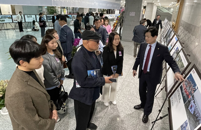 길종성 회장이 사진전 관람객에게 사진을 설명하고 있다. /독도사랑회