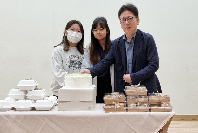 학생 대표와 최창성 교장이 함께 캐익을 절단하고 있다./남양초등