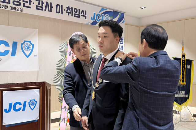 박주완 신임회장에게 회장메달을 걸고 있다./