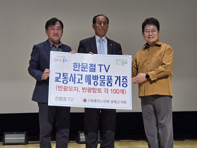 한문철 변호사가 노인회 봉화군지회에 교통사고 예방물품인 반광망토와 반광모자를 전달하고 있다./봉화군 제공