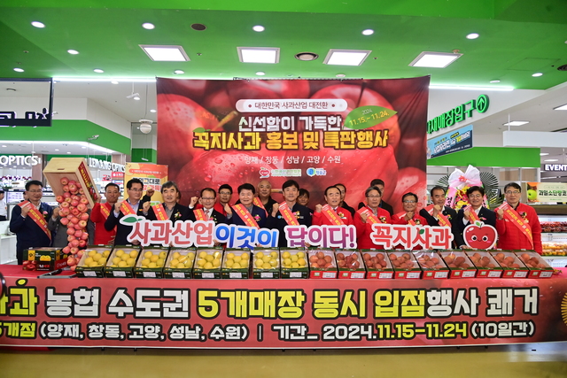 윤경희 청송군수(가운데)와 청송군 농협 및 사과협회 관계자들이 양재점 하나로마트에서 꼭지사화 홍보 기념촬영을 하고 있다./청송군제공