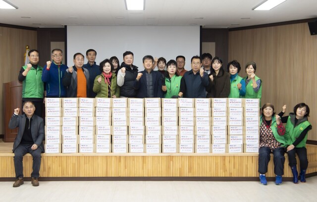 새마을회원들이 김장김치를 담아 포장을 끝내고 파이팅을 외치고 있다./울릉군새마을회