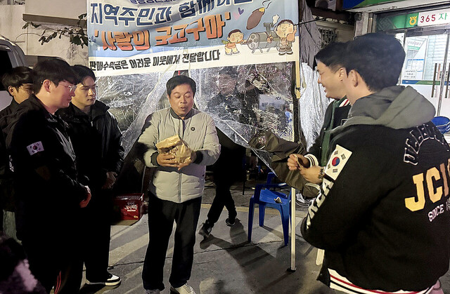 울릉JCI선배가 후배들의 군고구마 판매 현장을 찾아 후배들을 격려하고 있다./김두한 기자 
