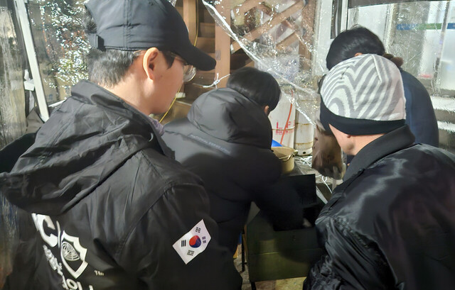 젊은 청년들의 군고구마 판매에 대한 의미를 안 주민이 군고구마를 구입하며 격려를 하고 있다. /김두한 기자 
