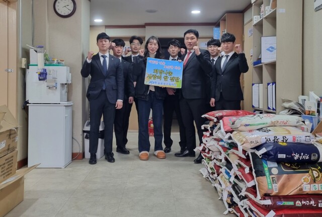 울릉청년회의소 회원들이 쌀을 전달하고 파이팅을 외치고 있다./가족센터
