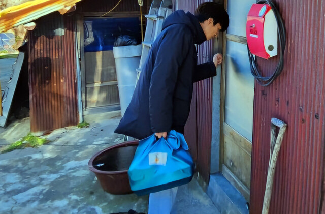 한전MCS(주) 울릉도 발전소봉사단원이 취약계층가정을 찾아 설 음식을 전달하는 모습./자원봉사센터