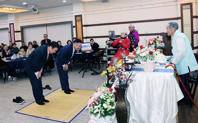 김재욱 칠곡군수(오른쪽)와 정희용 국회의원이 신봉균 어르신께 큰절을 올리며 존경을 표하고 있다. 가족과 주민들이 함께 자리해 따뜻한 분위기 속에서 백수연을 축하하고 있다. /칠곡군 제공