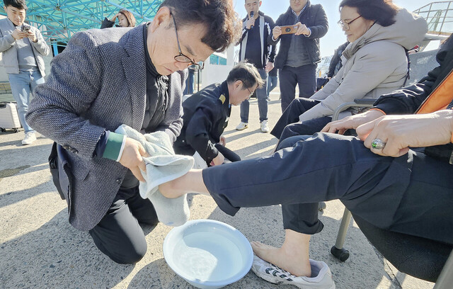 정홍 사장과 배상효 선장이 관광객의 발을 닦아주고 있다./대저페리