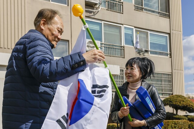 김금숙(오른쪽) 무성아파트 이장이 아파트 앞에서 주민에게 태극기를 건네며 삼일절 태극기 달기 운동의 의미를 설명하고 있다. /칠곡군제공