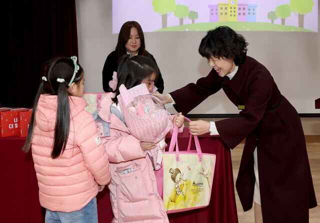 교장선생님이 신입생에게 학용품 등의 입학 축하 선물을 전달하고 있다. 