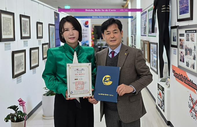 독도홍보관에서 길종성 독도사랑회 중앙회장(오른쪽)이 가수 풍금에게 위촉장을 전달하고 기념촬영./독도사랑회
