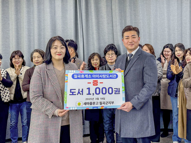 새마을문고 칠곡군지부 김명신 회장(왼쪽)과 전경진 칠곡휴게소 소장이 1000권의 도서를 기증하는 전달식을 진행하며 환하게 웃고 있다./칠곡군제공
