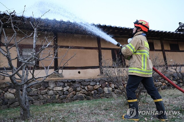 안동 하회마을 주택 지붕에 물을 뿌리고 있는 소방대원./연합뉴스